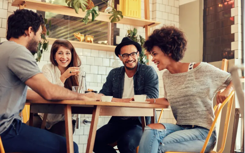 夫婦が2組集まって、食事会をしている様子の写真。みんなが笑顔でテーブルを囲んでいる