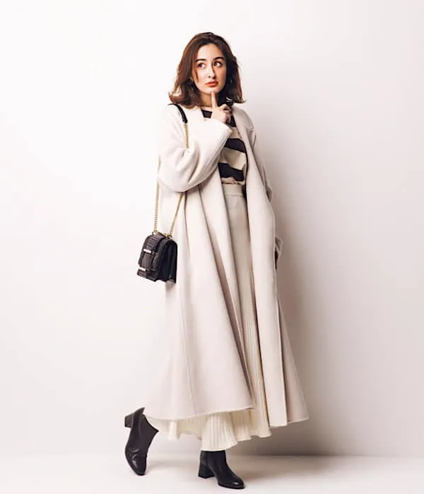 茶色ボーダー × 白プリーツスカート × 白コート × 黒小物 の大人カジュアルなボーダーコーデ