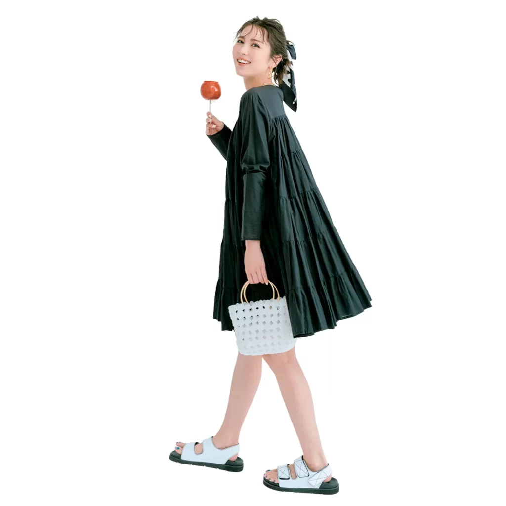 Aラインの膝丈黒ワンピースに白のスポーツサンダルを履いたコーディネート。