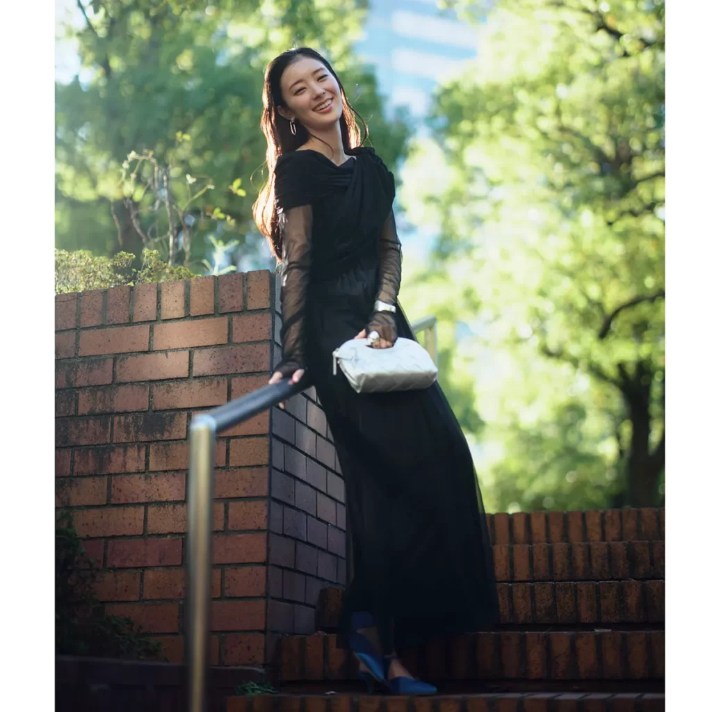 チュールを重ねたブラックドレスにシルバーのバッグを持った記念日コーデ。