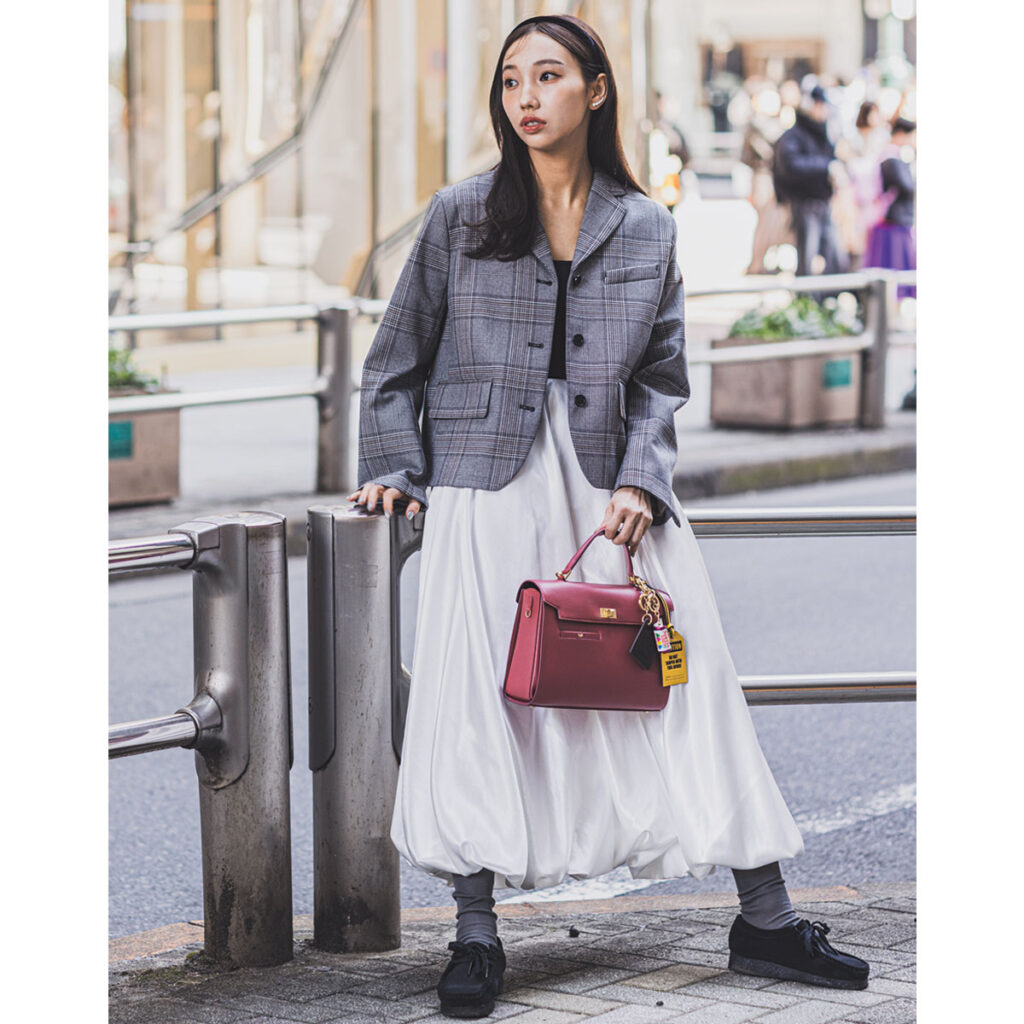 チェックの短丈ジャケットと白スカートのコーデ