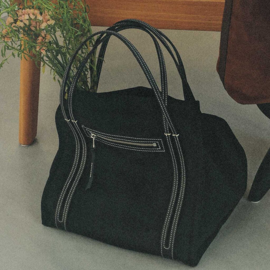 ブラックスエードに白のステッチのバッグ