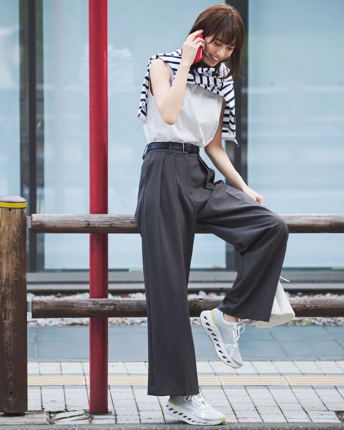 白のタンクトップにグレーのワイドパンツ、白スニーカーを合わせた女性