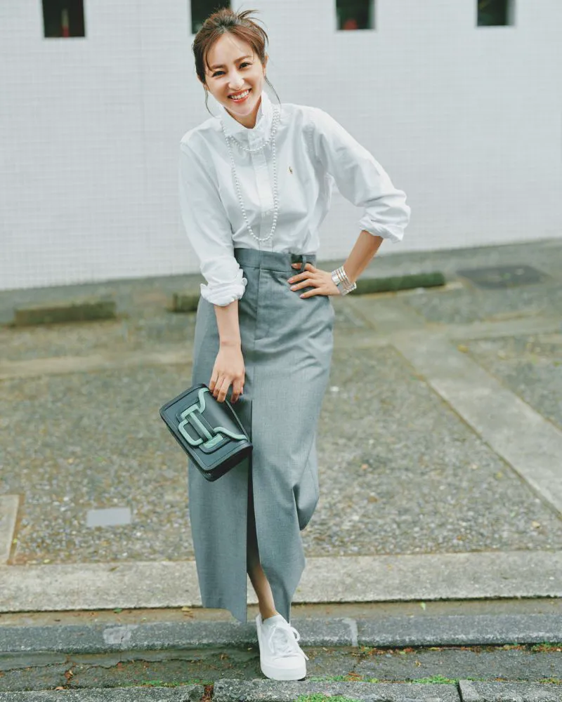 白シャツにグレーのタイトスカート、白スニーカーを履いた女性
