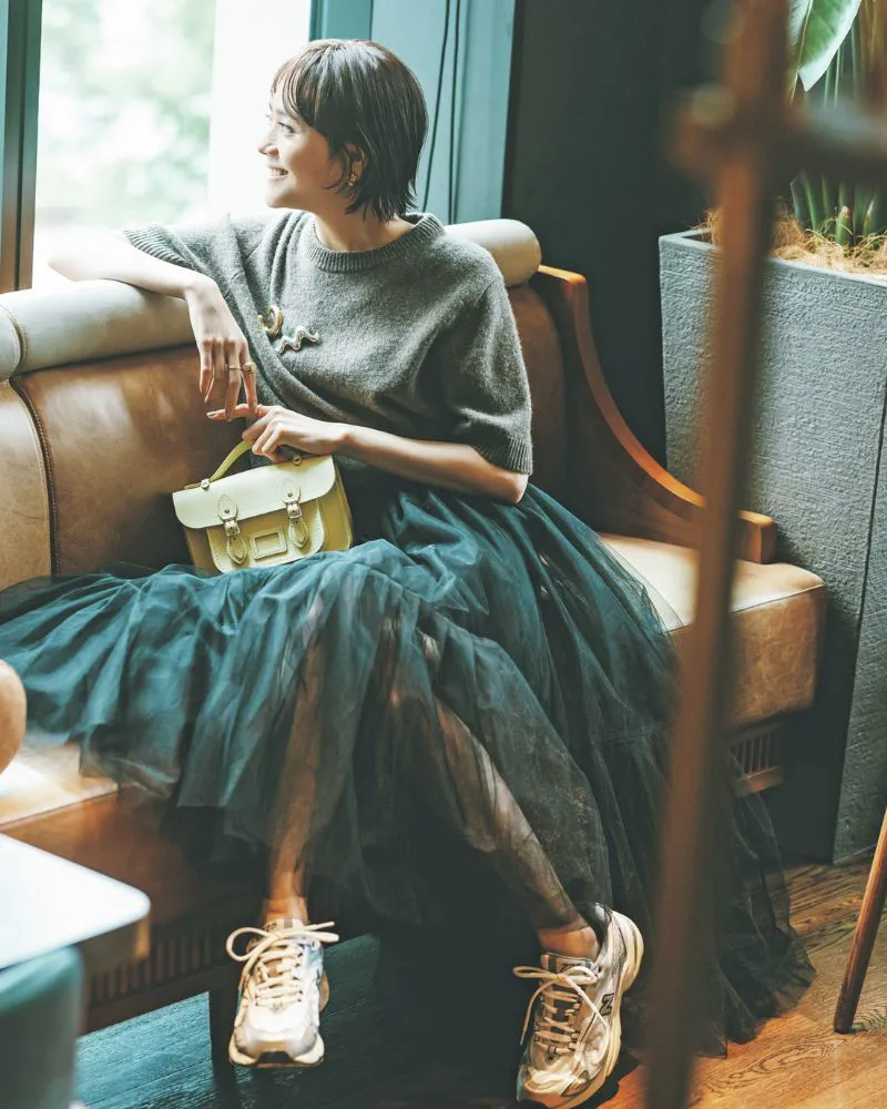 半袖ニットにチュールスカート、白スニーカーを履いた女性