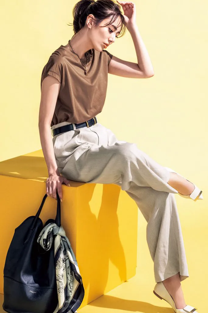 キャメルのTシャツ、ベージュのパンツ、白パンプスを履いた女性