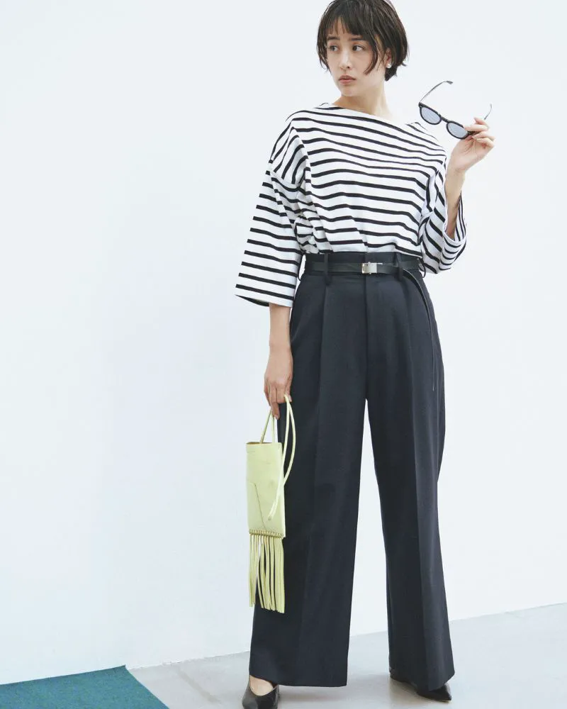 ぼーだーTシャツ、ワイドパンツ、黒のパンプスを履いた女性