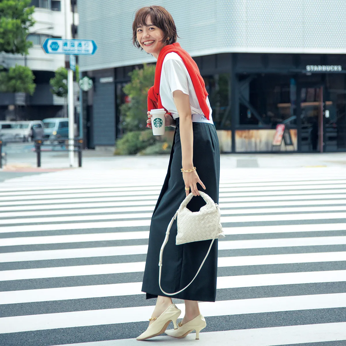 夏のオフィスカジュアルコーデでおすすめの赤のカーディガンを肩がけした、白Tシャツ×ペンシルスカート姿の松井愛莉さん