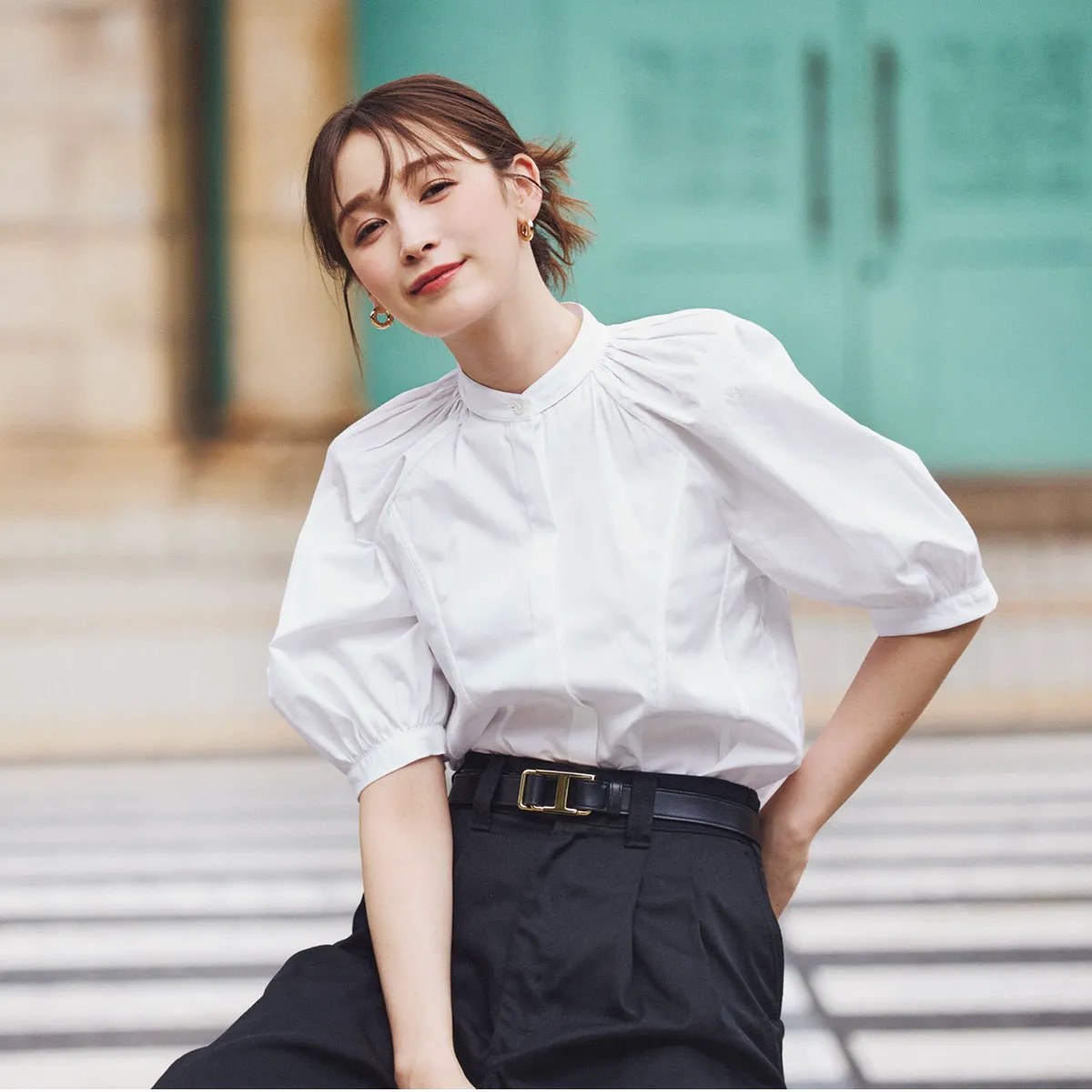 夏のオフィスカジュアルコーデでおすすめのボリューム袖の白ブラウス×黒タックパンツの藤井サチさん