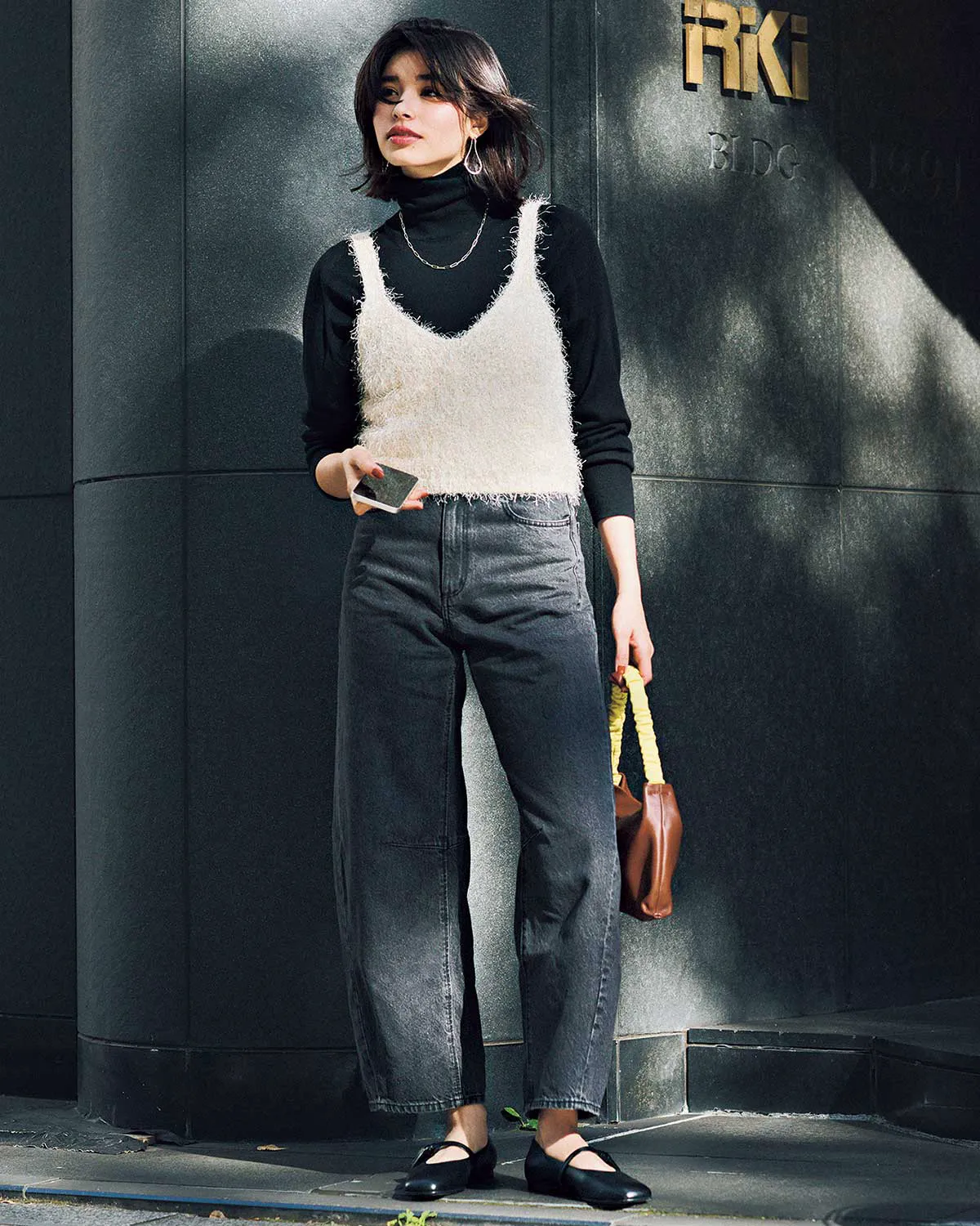 白キャミソール、黒のタートルネックニット、ブラックデニムパンツを合わせた冬のデニムコーデ