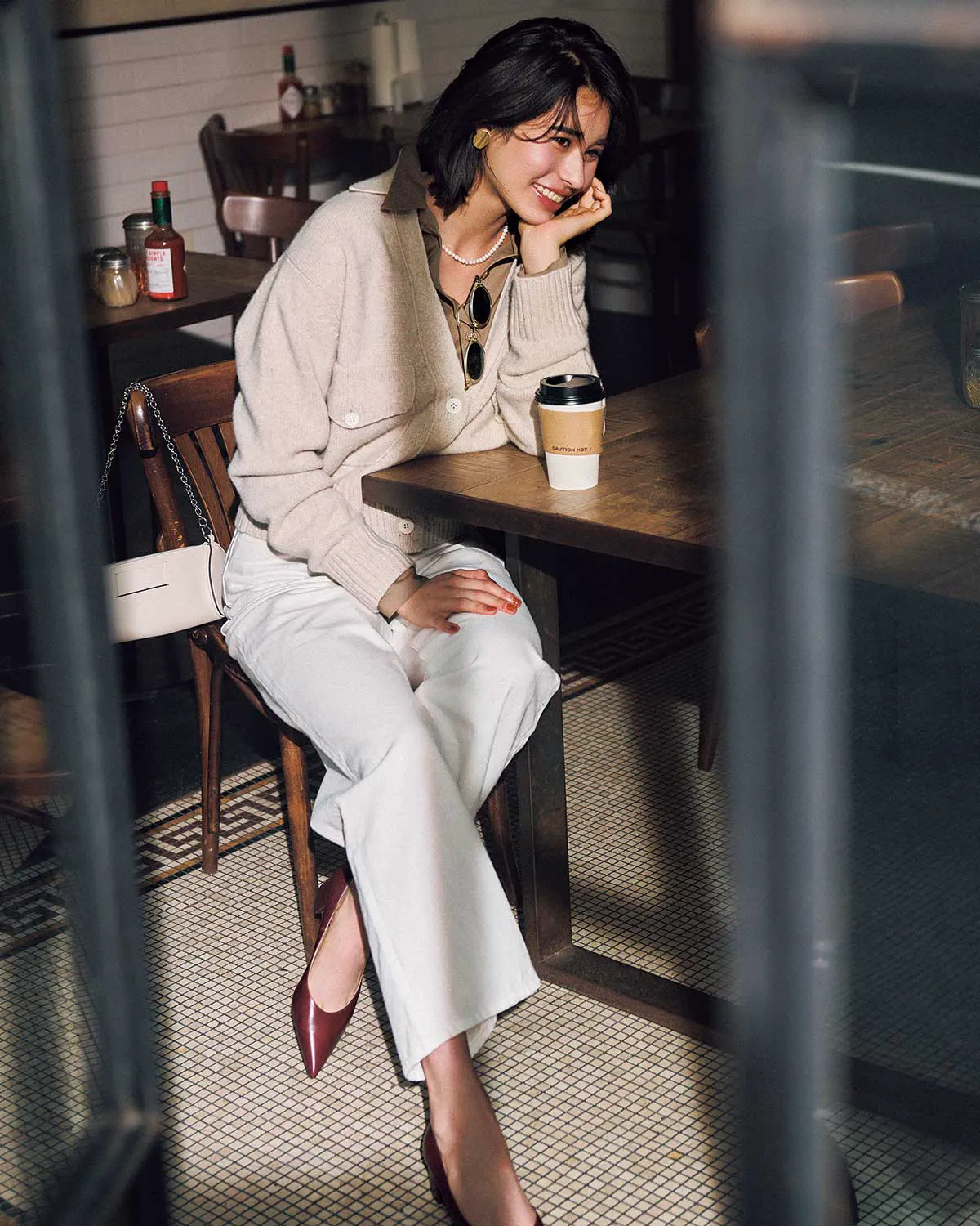 ベージュカーディガン、ベージュシャツ、白のデニムパンツを合わせた冬のデニムコーデ