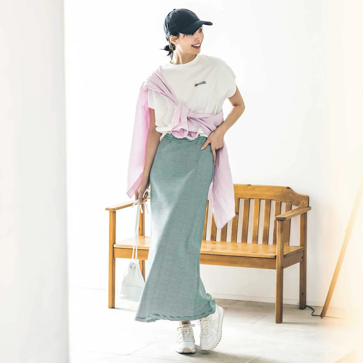 Tシャツ、ロングスカート、スニーカーを履いた女性