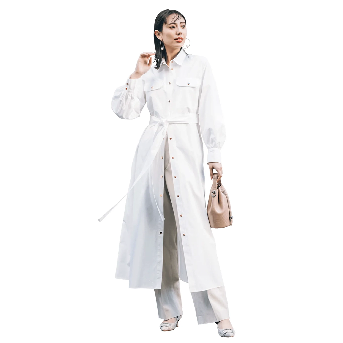 白のシャツワンピース、ベージュのパンツを履いた女性