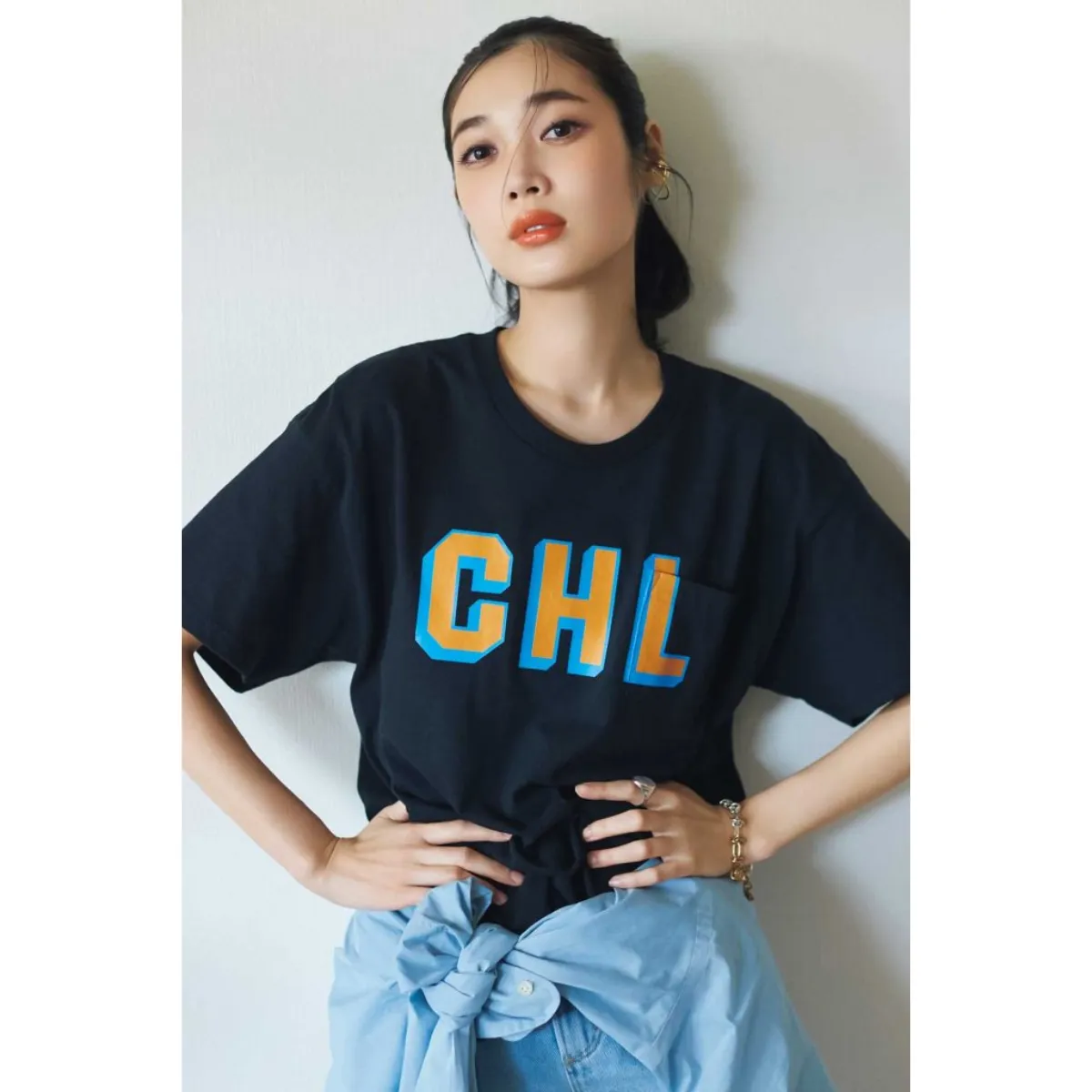 ロゴ入りの黒T×パンツにシャツを巻いた林田岬優さん