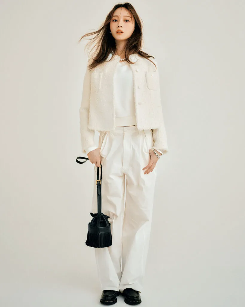 白のチノパン、スウェットトップス、ツイードジャケットに黒のシューズとバッグを合わせたコーデ