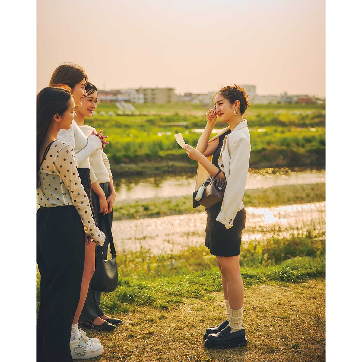 ニットタンクとミニスカートのブラックコーデに短丈白ジャケットのコーデ