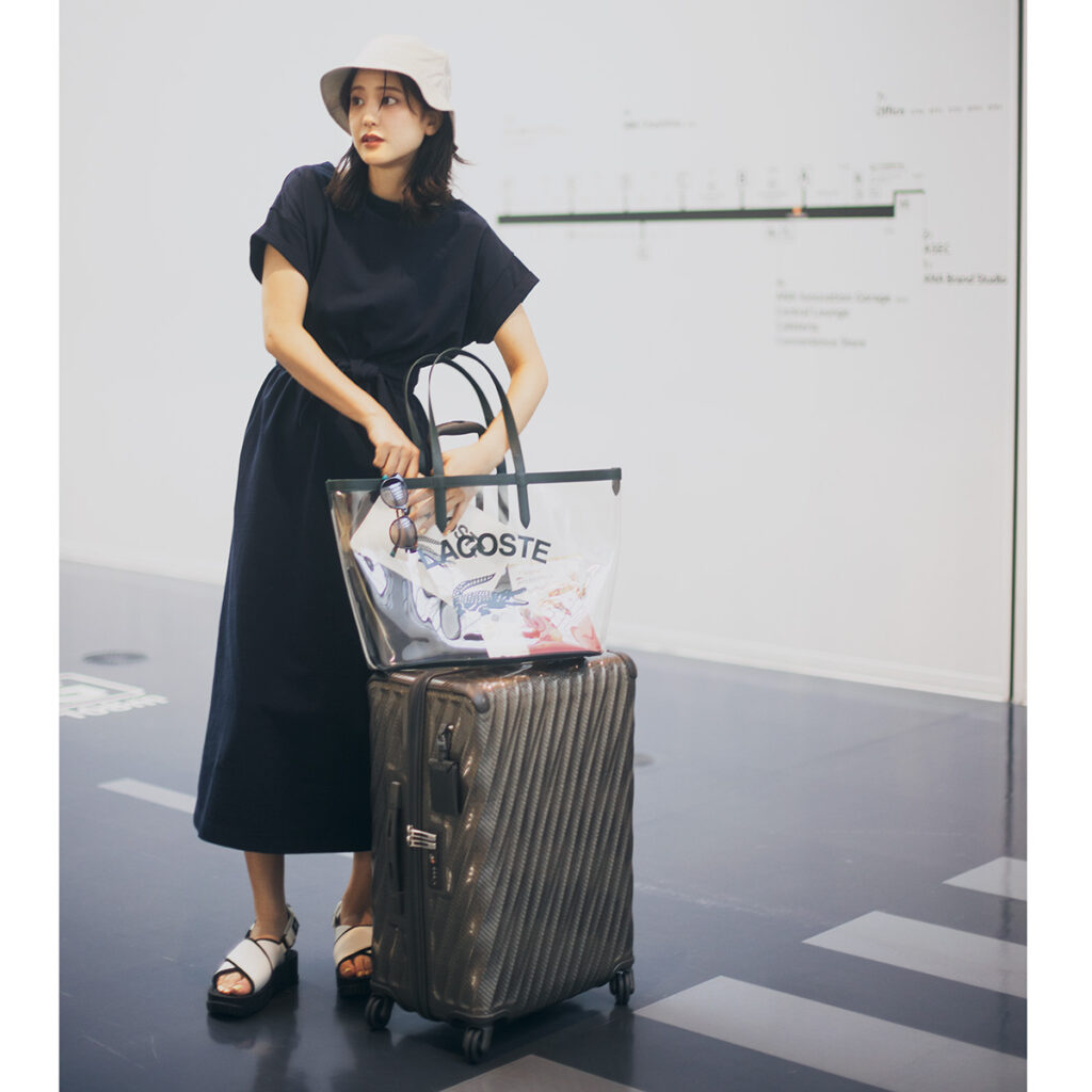 ネイビーの半袖ワンピにPVCバッグの旅コーデ