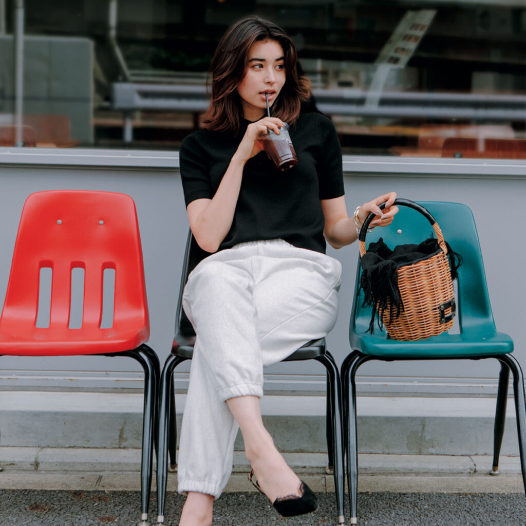 黒のポロニットに白のスウェットパンツにエバゴスの黒レザーかごバッグ