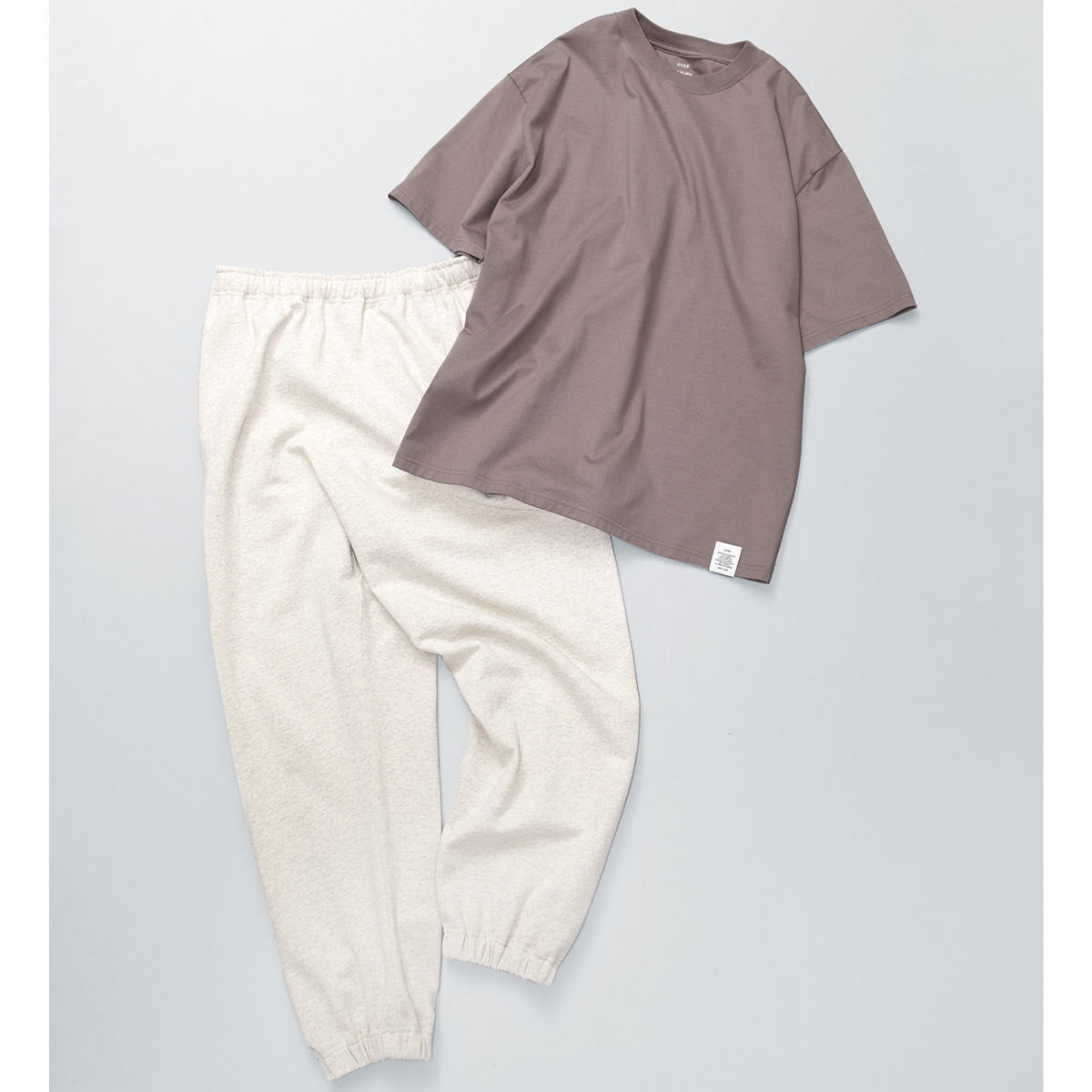 ブラウンのTシャツと白のスウェットパンツ