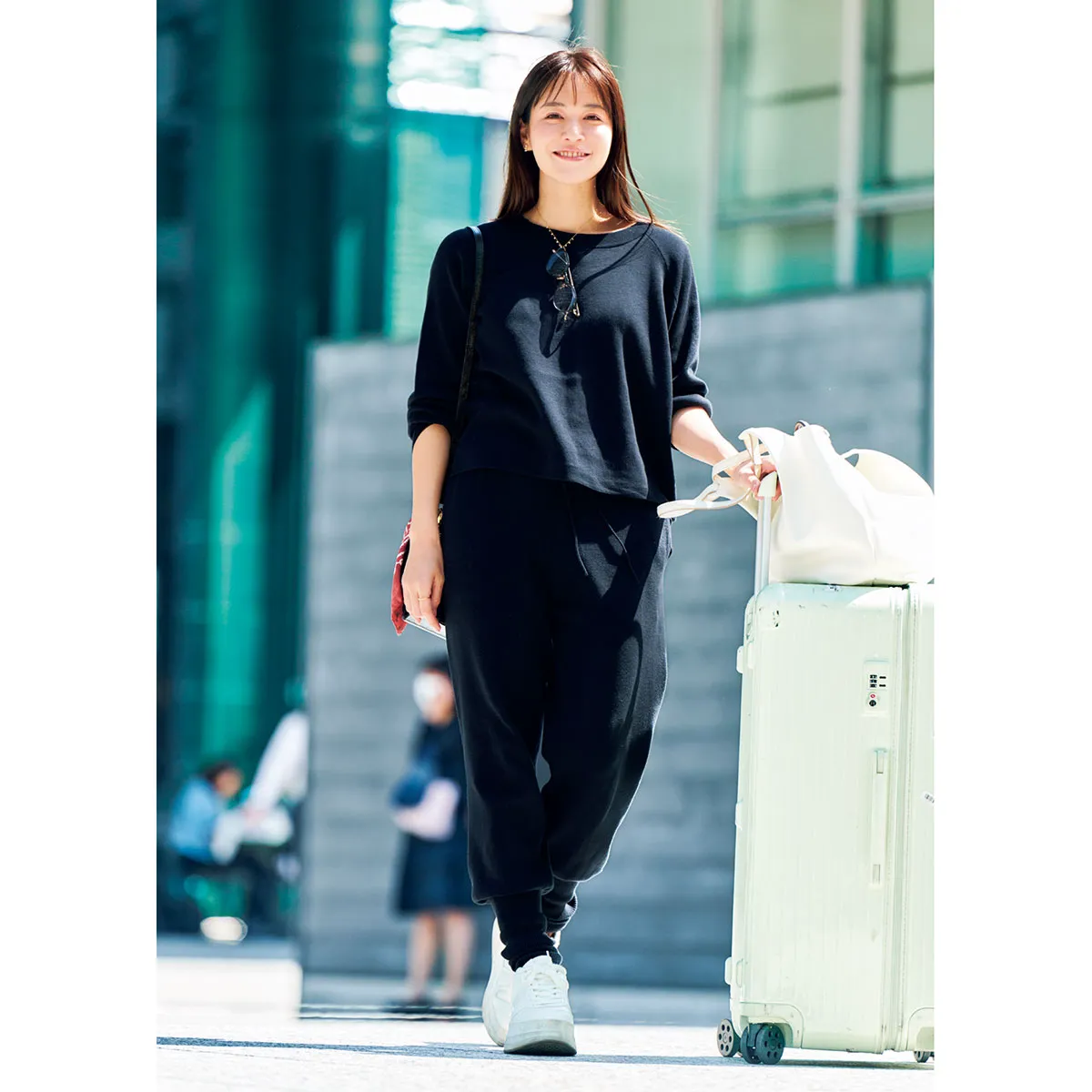 空港コーデにおすすめの黒のニットセットアップ姿の石井里奈さん。