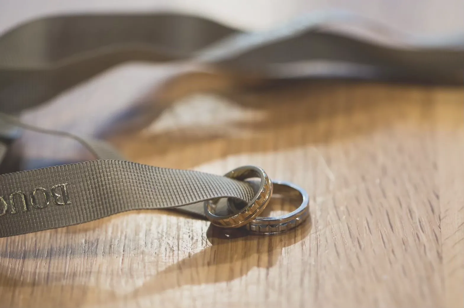 ブシュロンの結婚指輪が2つ重なっている様子。指輪にはブシュロンのリボンが通されている。