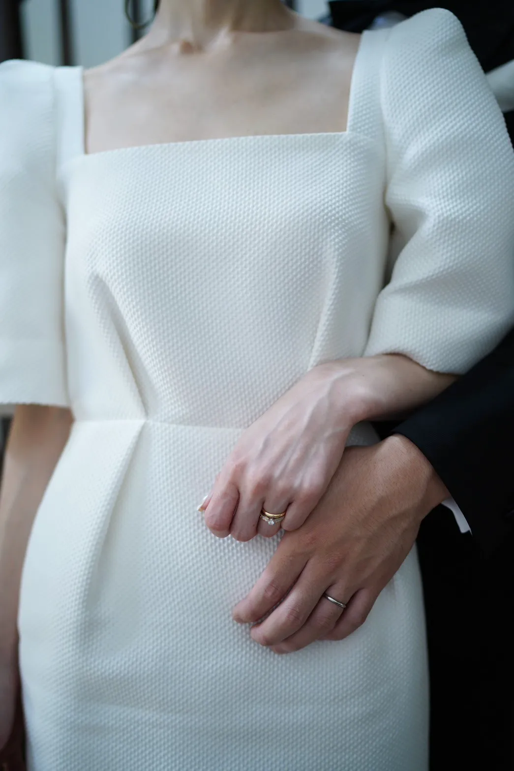 ブシュロンの婚約指輪とカルティエの結婚指輪をつけている植田 舞さんと、カルティエの結婚指輪をつけている植田 悠太郎さんの手元を捉えた写真。