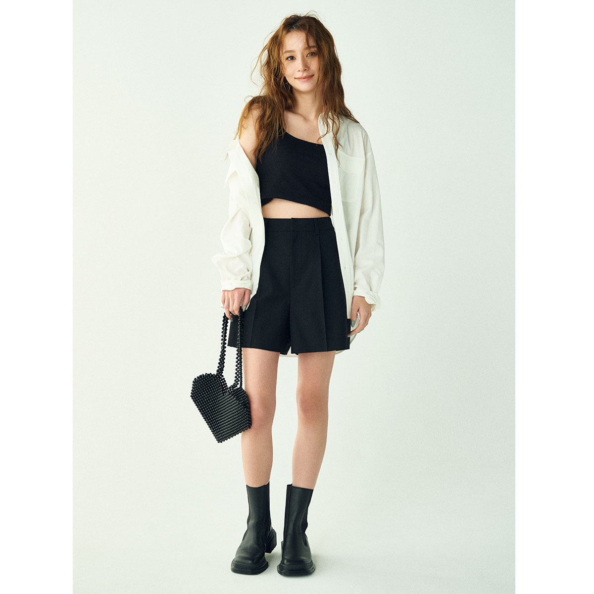 タンクトップとミニボトムスにブーツのモノトーンコーデ