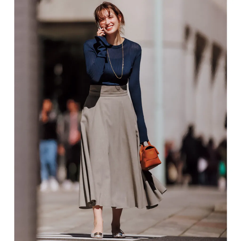 ブラウンのフレアスカート×ネイビートップスのトラウデン直美さん