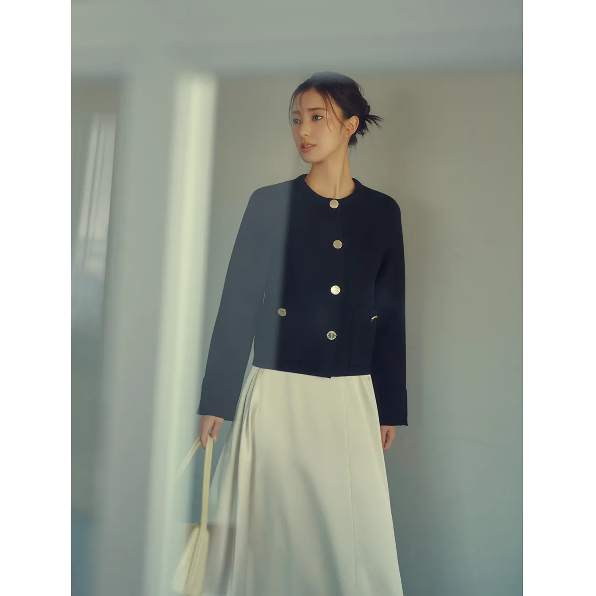 白のフレアスカート×ニットジャケットの宮本茉由さん