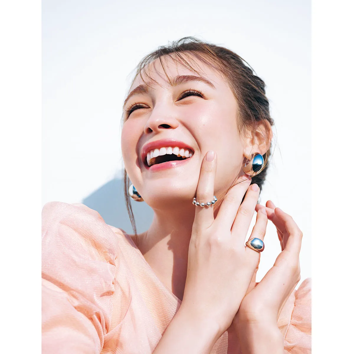 e.m.のリングとイヤリングをつけた藤井サチさん。