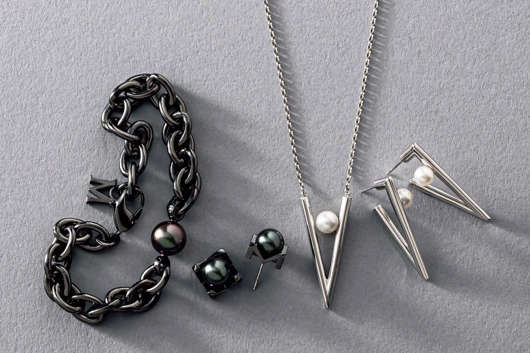 右から順に、ミキモトのピアス「Vコード」、ペンダント「Vコード」、ピアス「パッショノワール」、ブレスレット「パッショノワール」が並んでいる様子。