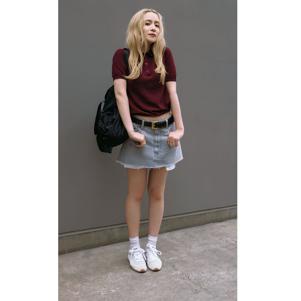 ミュウミュウのポロニットとデニムミニに白スニーカーのコーデ