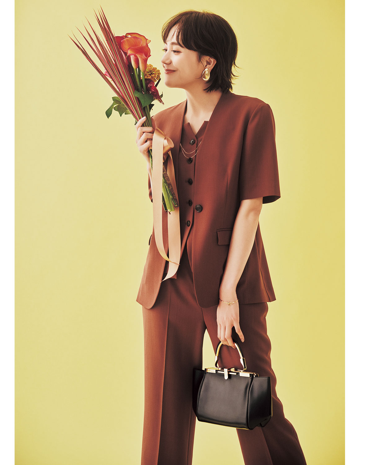 茶色のハーフスリーブジャケットにビスチェとパンツを合わせた冬の結婚式参列にふさわしい服装