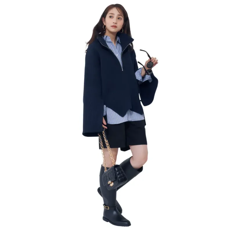 ベーシックな白シャツにジップ付きスキッパーニットを重ね、ショートパンツとロングブーツを合わせたコーデ