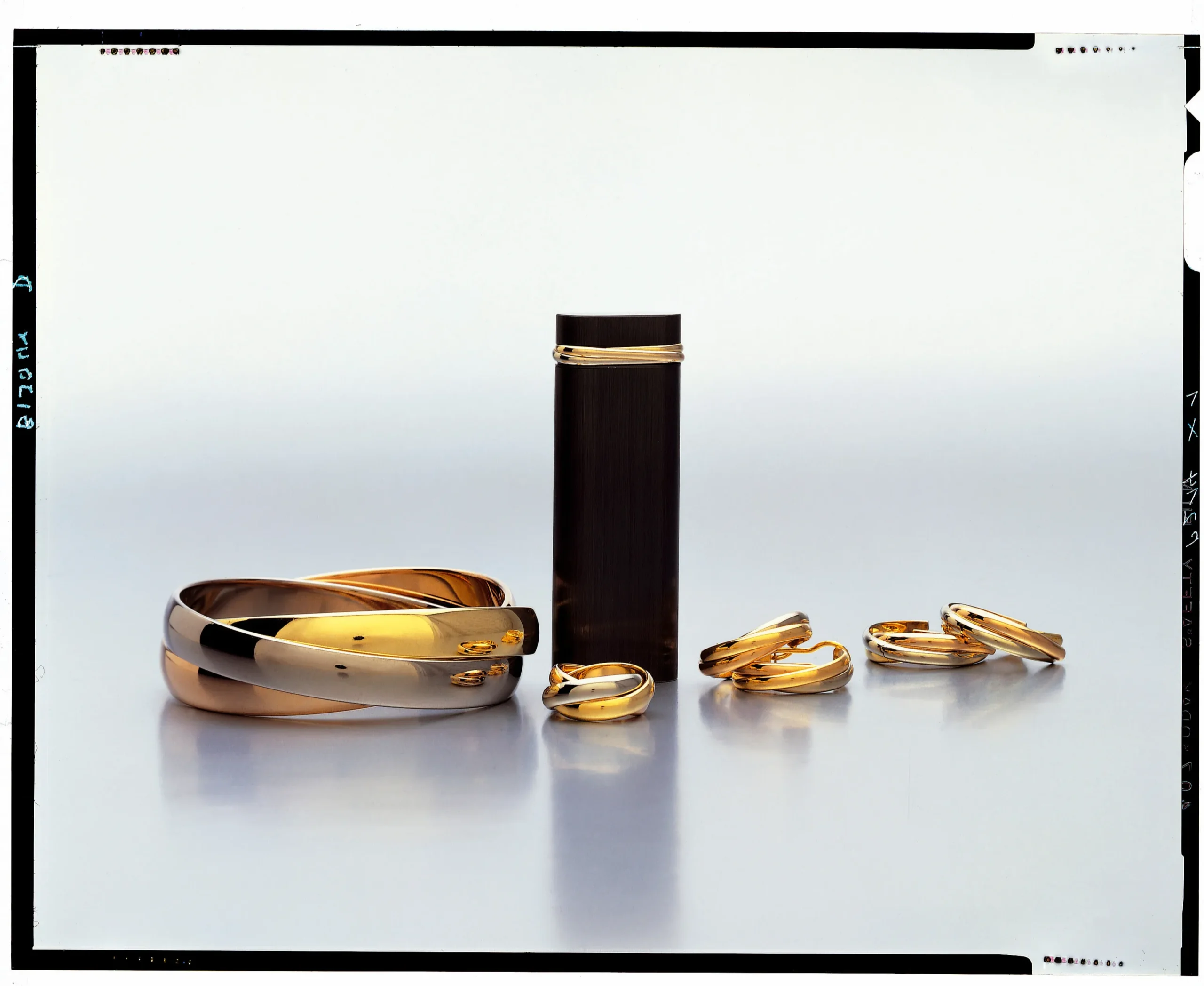 カルティエの「トリニティ」コレクション。左から、ブレスレット、ライター、リング、イヤリングが並んでいる様子。