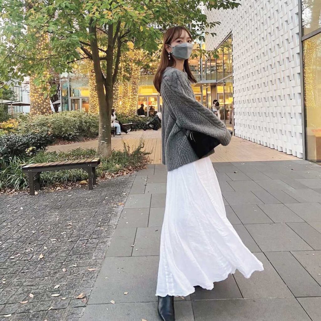 グレーニットと白スカートのコーデ