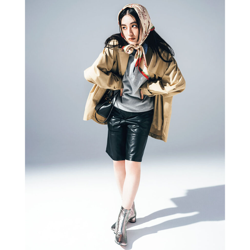 レザーハーフパンツとミディアム丈のトレンチコートのモードスタイル