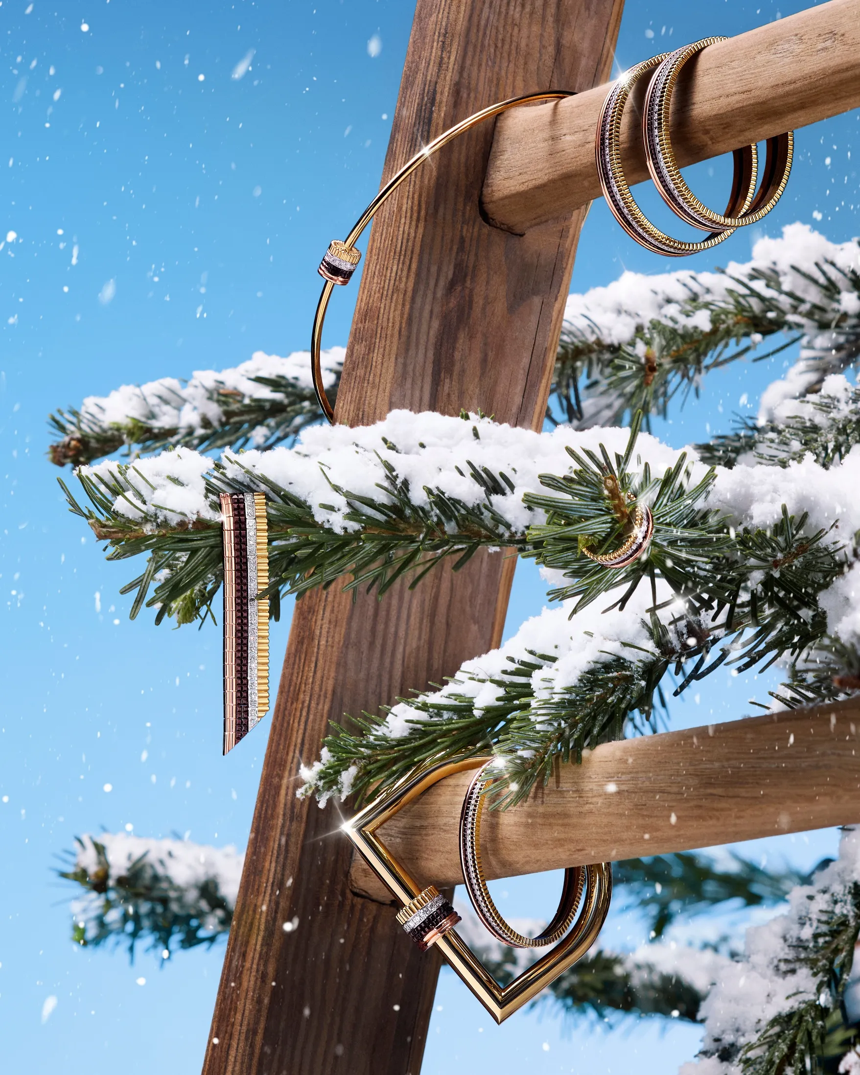 梯子や雪が積もった木にブシュロンの「キャトル」ブレスレットやリング、イヤリング、ネックレスがかかっている様子。