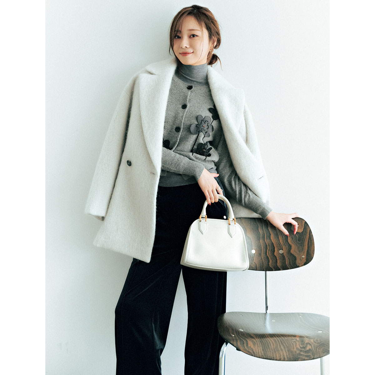 フラワーモチーフカーディガンと黒のベロアパンツのコーデ