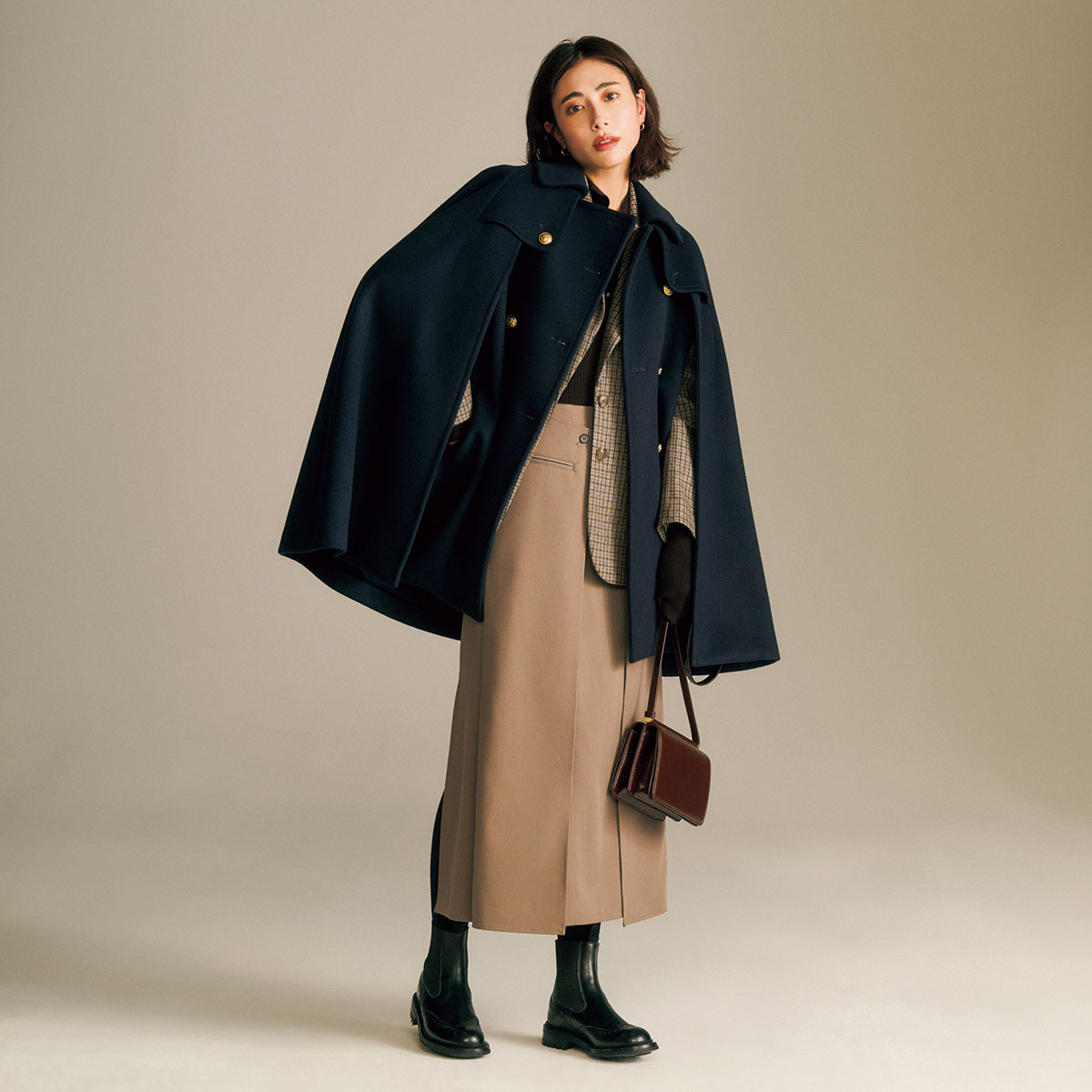 ケープジャケットとブラウンのスリット入りスカートのコーデ