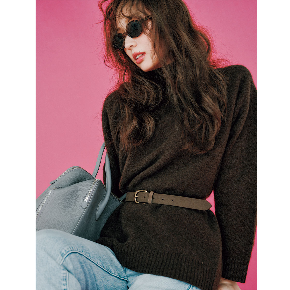 長め丈のタートルとデニムパンツにスウェードベルトでウエストマークしたコーデ