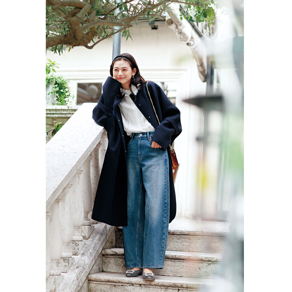 レース襟のブラウスにデニムパンツとロングコートのコーデ