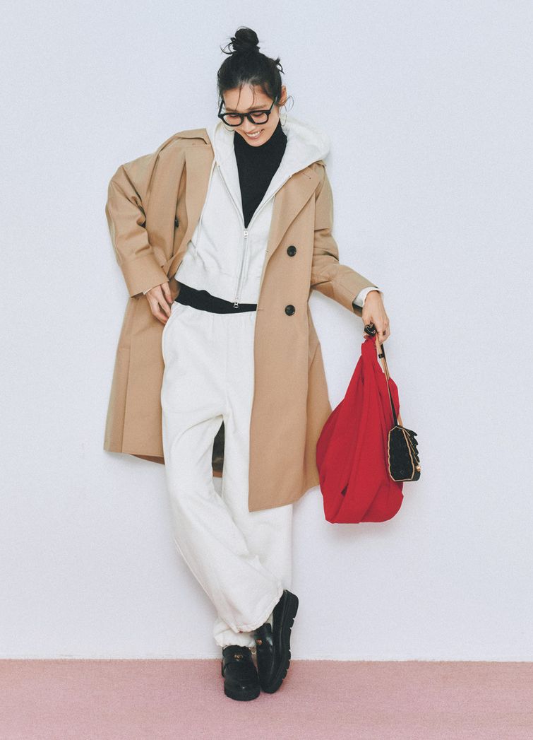 白のスウェットセットアップで可愛げあり。黒タートルとトレンチを合わせた、トラッドとゆるさのバランスが新鮮です。トップスはコンパクトなサイズのものを選ぶのが得策のよう。スウェットパンツとパーカはミースロエ、コートはティッカ、ニットはノーク、靴は銀座かねまつ、バッグ小はMARY AL TERNA、バッグ大はACOCのもの。