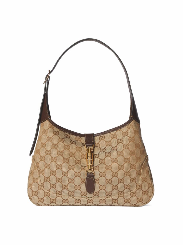 グッチ ジャッキー 1961。ベージュのGGキャンバスの半月型バッグにゴールド金具とレザーハンドル付き