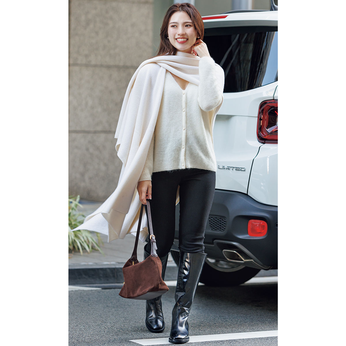 白ニットに黒デニムとロングブーツのコーデ