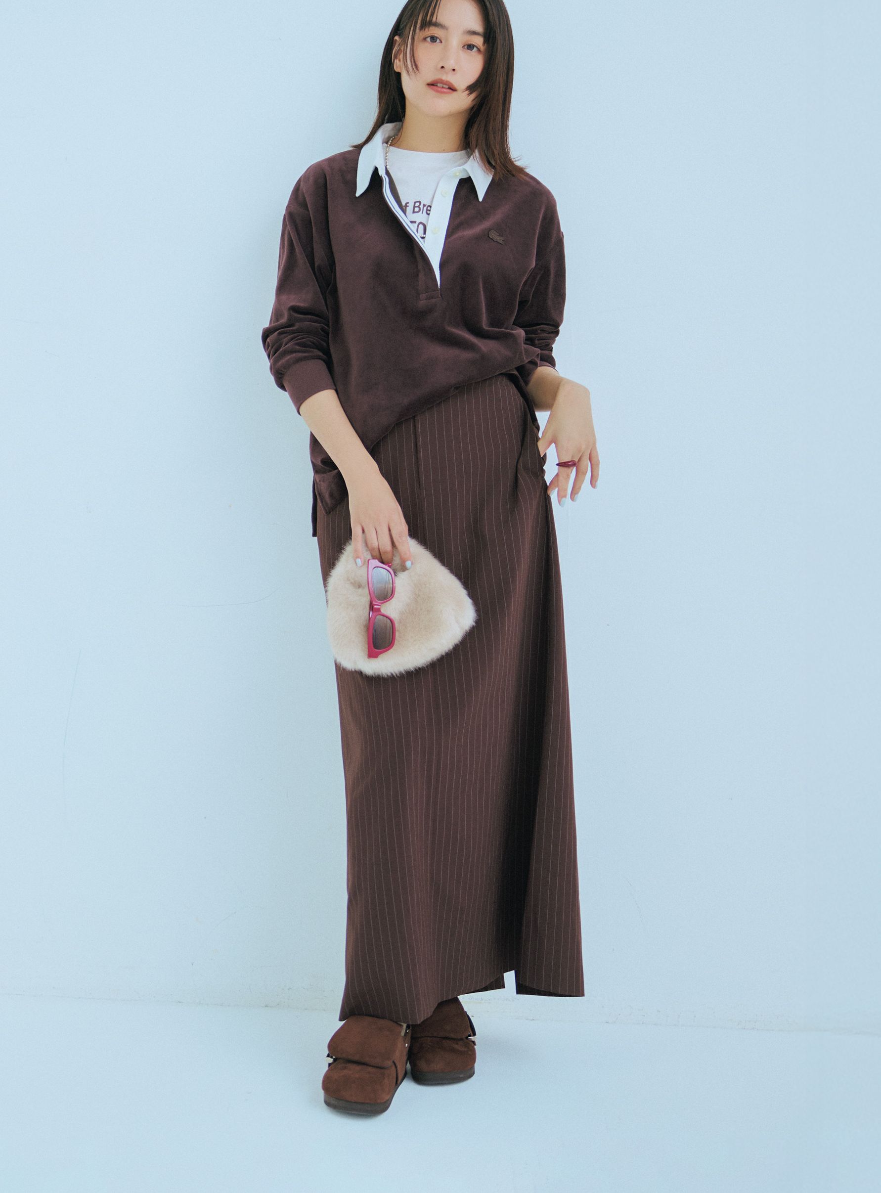 上下ブラウンでラガーシャツコーデがシックで大人っぽい。靴もインナーのTシャツのロゴも茶で合わせて、まるでセットアップのようなキレイ具合です。ラガーシャツはラコステ、Tシャツはエリオポール、スカートはミースロエ、バッグはアモーメント、靴はピッピシックのもの。