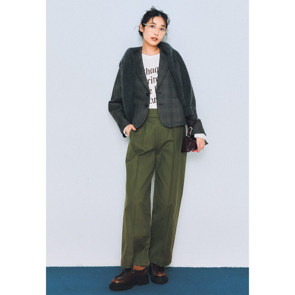 グレーのチェックジャケットとカーキのパンツにクリアフレームメガネのコーデ