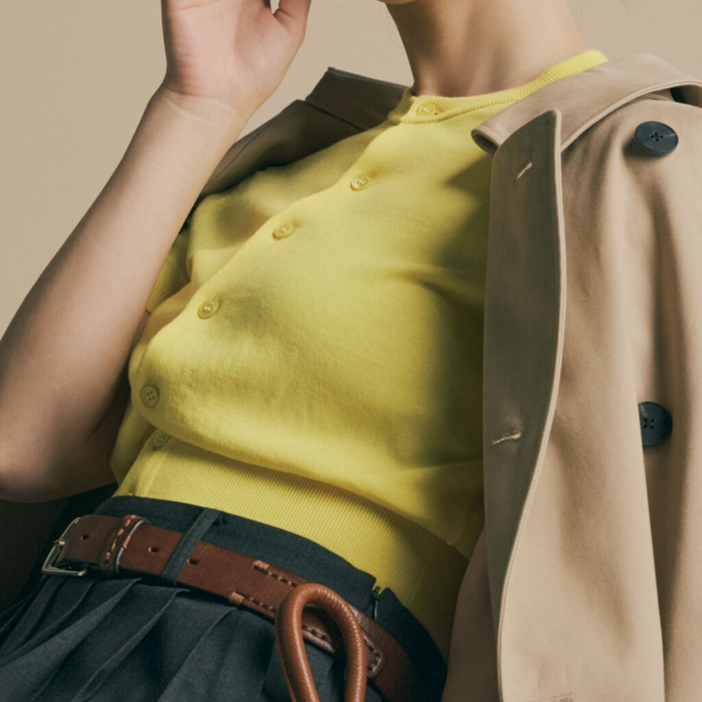 イエローカーデにトレンチコートのコーデ