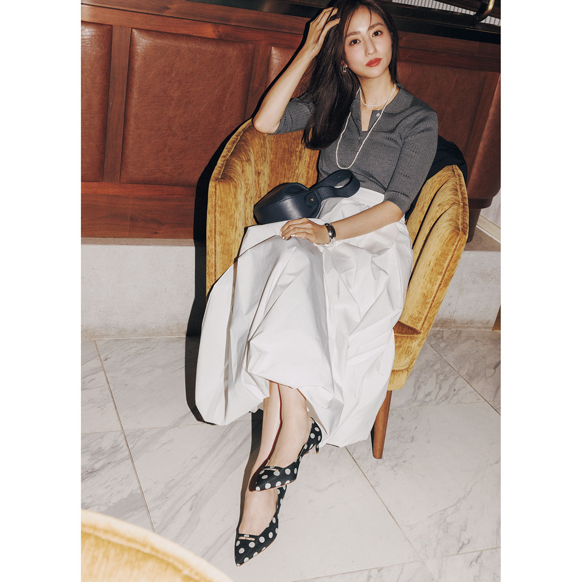白のボリュームスカートにドット柄パンプスのキレイめコーデ
