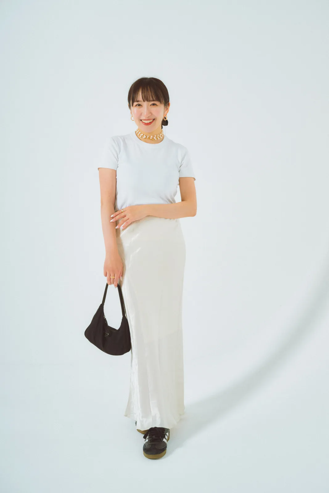 きれいめスニーカーコーデにおすすめの白Tシャツ×白サテンスカート×黒スニーカーの田村有希さん